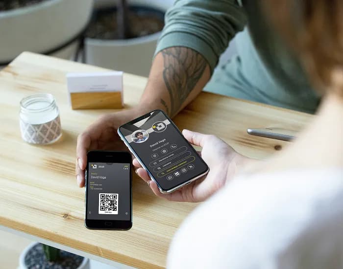 Zwei Personen, die über ihre Mobiltelefone IDQR-Visitenkarten austauschen